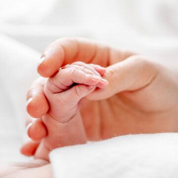 mother-holding-newborn-baby-hand-2023-01-06-06-49-38-utc-scaled.jpg Povestea mamei care a stat 20 de ani în închisoare, NEVINOVATĂ, acuzată că și-a sufocat copiii. Gena fatală care le-a cauzat moartea